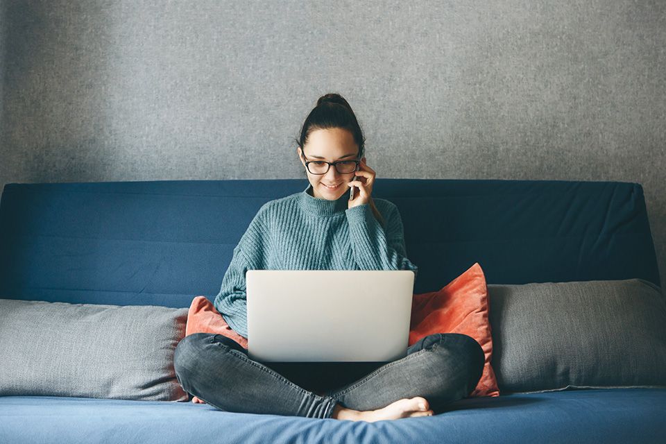 Foto: Frau mit Laptop auf Couch