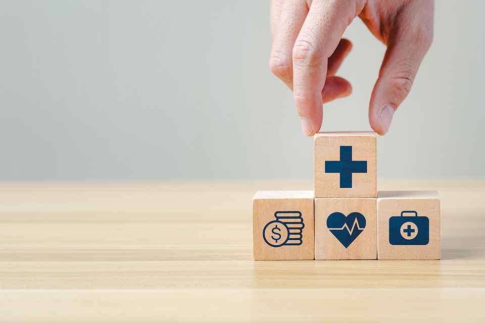 Foto: Hand legt einen Holzblock auf andere Blöcke